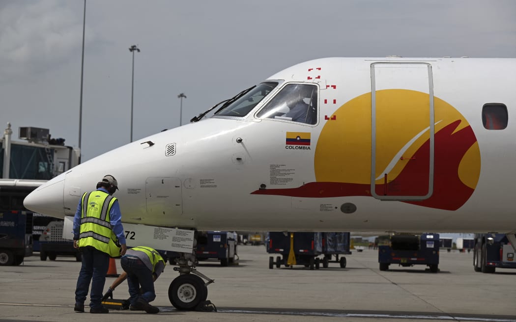 A Satena Airlines aircraft covering the route Bogota-Caracas is pictured upon arrival at Simon Bolivar International Airport in Maiquetia, La Guaira State, Venezuela, on November 9, 2022. The resumption of flights between Venezuela and Colombia followed the reestablishment of bilateral relations after Colombian president Gustavo Petro came to power last August 7. Venezuela and Colombia broke diplomatic ties in 2019 after Colombian President Ivan Duque (2018-2022) disowned Venezuelan President Nicolas Maduro and accepted opposition leader Juan Guaidó as a peer. (Photo by Federico PARRA / AFP)