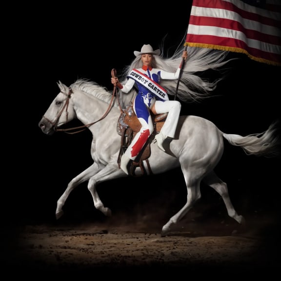 Cover image from Beyoncé's album 'Cowboy Carter'. Beyoncé sits side-saddle on a grey horse in red, white and blue outfit, cowboy hat and carrying the American flag.