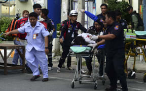 Rescue workers help an injured victim after a string of small bombs exploded in the Thai resort town of Hua Hin.