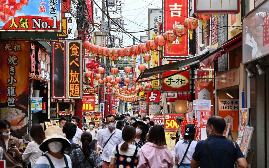 This photo taken on September 17, 2022 shows people walking down a street in the Chinatown section of Yokohama, Kanagawa prefecture, south of Tokyo. - Inflation in Japan hit 2.8 percent in August, the highest level since 2014, government data showed on September 20, 2022 as soaring energy prices bite. (Photo by Richard A. Brooks / AFP)