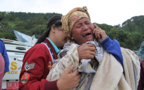 A woman cries as she finds out her family are listed as missing, at the Lake Toba ferry port in the province of North Sumatra on June 19, 2018, after a boat capsized the day before.