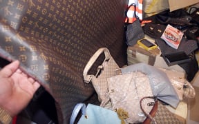 un douanier montre, le 23 juillet 2001 à l'aéroport de Roissy, une contrefaçon du tissu servant à faire des sac de voyage, comme ceux de Louis Vuitton. L