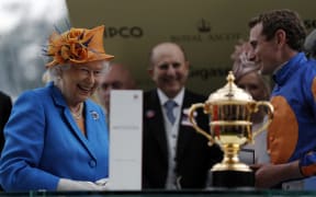 Queen Elizabeth II prepares to present jockey Ryan Moore, right, the Gold Cup after riding Order of St George win the main race during Ladies' day at Royal Ascot horse racing meet in Ascot, west of London on 16 June, 2016.