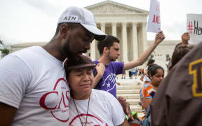 Rosario Reyes, an undocumented mother from El Salvador, reacts to news on a Supreme Court decision blocking Obama's immigration plan, which would have protected millions of immigrants from deportation, in front of the US Supreme Court.