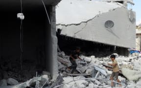 Syrian children check a damaged house, reportedly hit by US-led coalition air strikes.