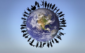 Silhouette of cheering people against bright blue sky