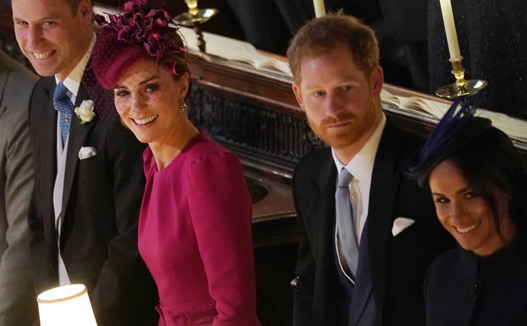 Britain's Prince William, Duke of Cambridge (L) Britain's Catherine, Duchess of Cambridge (2L), Britain's Prince Harry, Duke of Sussex and Meghan, Duchess of Sussex react during the wedding ceremony of Britain's Princess Eugenie of York and Jack Brooksbank at St George's Chapel, Windsor Castle.