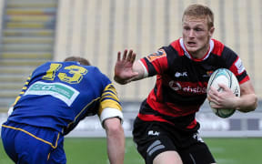 Johnny McNicholl of Canterbury looks to fends off Matt Faddes of Otago.