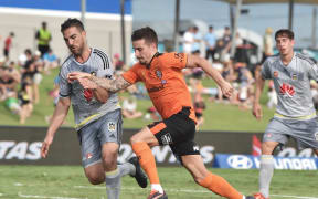 Roar player Jamie McLaren clashes with Phoenix's Emmanuel Muscat.