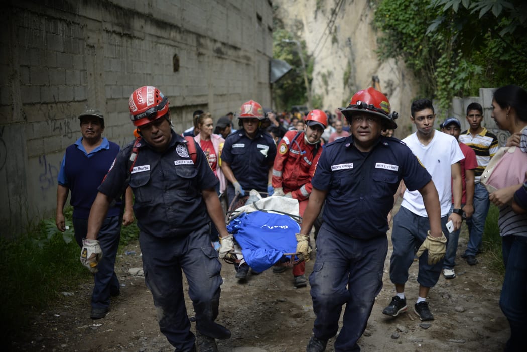 Rescuers carry a victim after a landslide at Cambray village