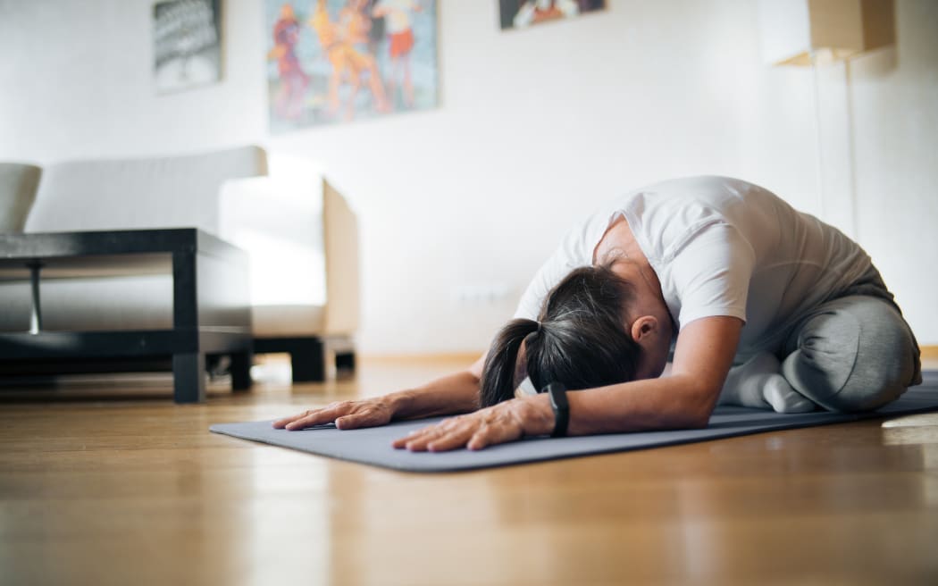 woman stretching on yoga mat