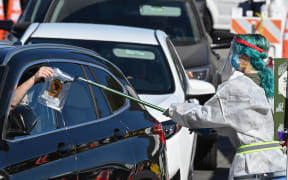 A healthcare worker collects a self-administered coronavirus test at a testing site in Los Angeles, California on 30 November 2020