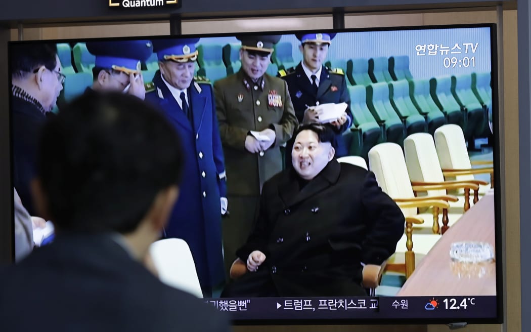 A man watches a TV news program reporting about North Korea's test-fire of a "new-type tactical guided weapon," with a footage of North Korean leader Kim Jong Un.