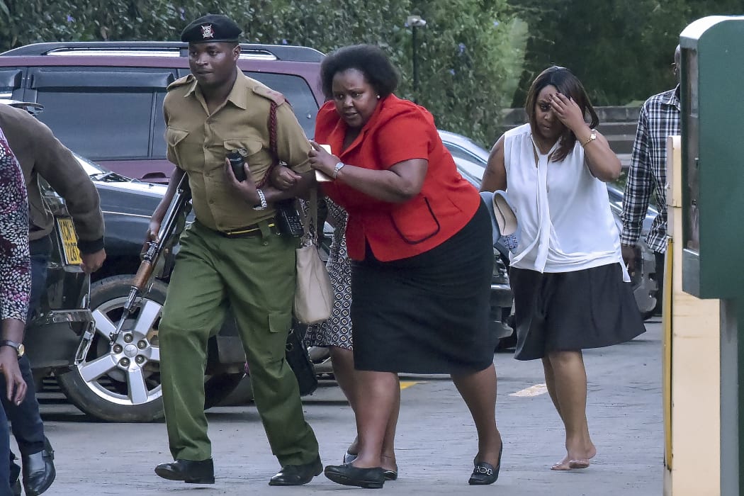 People are evacuated as a gunfight was underway following a blast at a hotel and office complex in Nairobi on January 15, 2019.