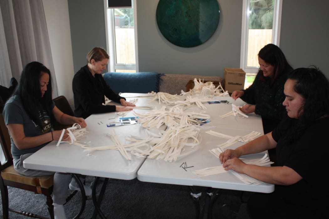 Whanau gather at Maraea's house to help with her kete installation.
