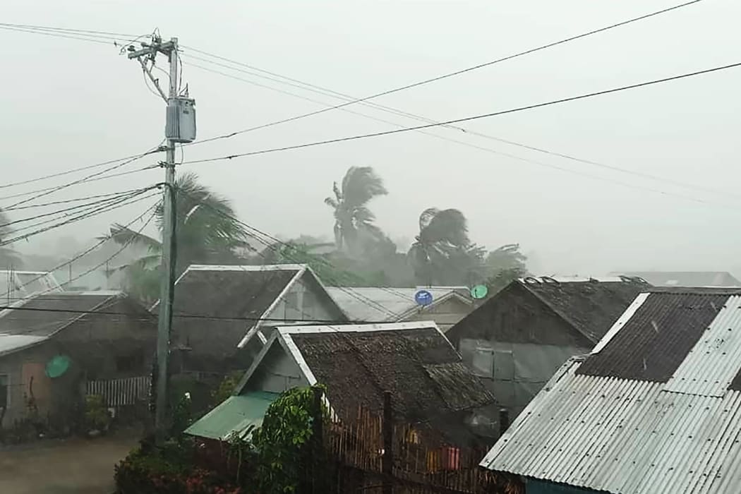 This handout image taken and received on December 2, 2019 courtesy of Gladys Vidal shows heavy rains and moderate wind from Typhoon Kammuri battering houses in Gamay town, Northern Samar province. -