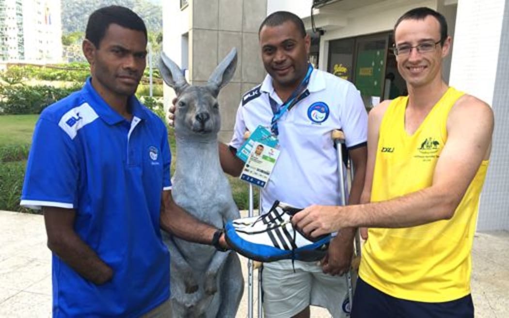 Fiji high jumper Epeli Baleibau (L) is presented with his new shoes by Australia's Aaron Chatman (R).