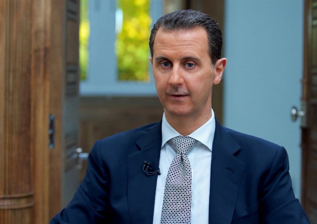A handout picture released by the Syrian presidency's press office shows Syrian President Bashar al-Assad during an interview with AFP in the capital Damascus, on April 12, 2017.