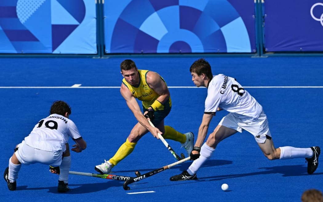 Australia's forward #05 Tom Wickham is marked by New Zealand's midfielder #19 Joseph Morrison and New Zealand's defender #08 Charlie Morrison in the men's pool B field hockey match between New Zealand and Australia during the Paris 2024 Olympic Games at the Yves-du-Manoir Stadium in Colombes on August 1, 2024. (Photo by Miguel MEDINA / AFP)