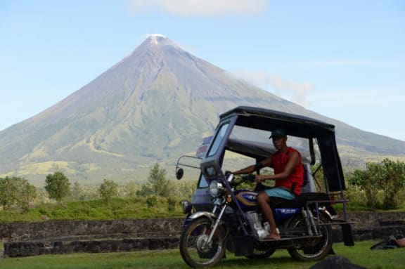 A motorised tricycle speeding past the Mayon volcano, pictured in 2014.