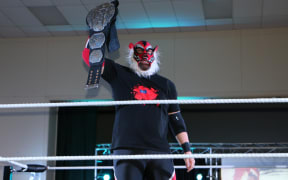 Liger/Michel Mulipola holds up his NZ Pro-Wrestling Championship belt.
