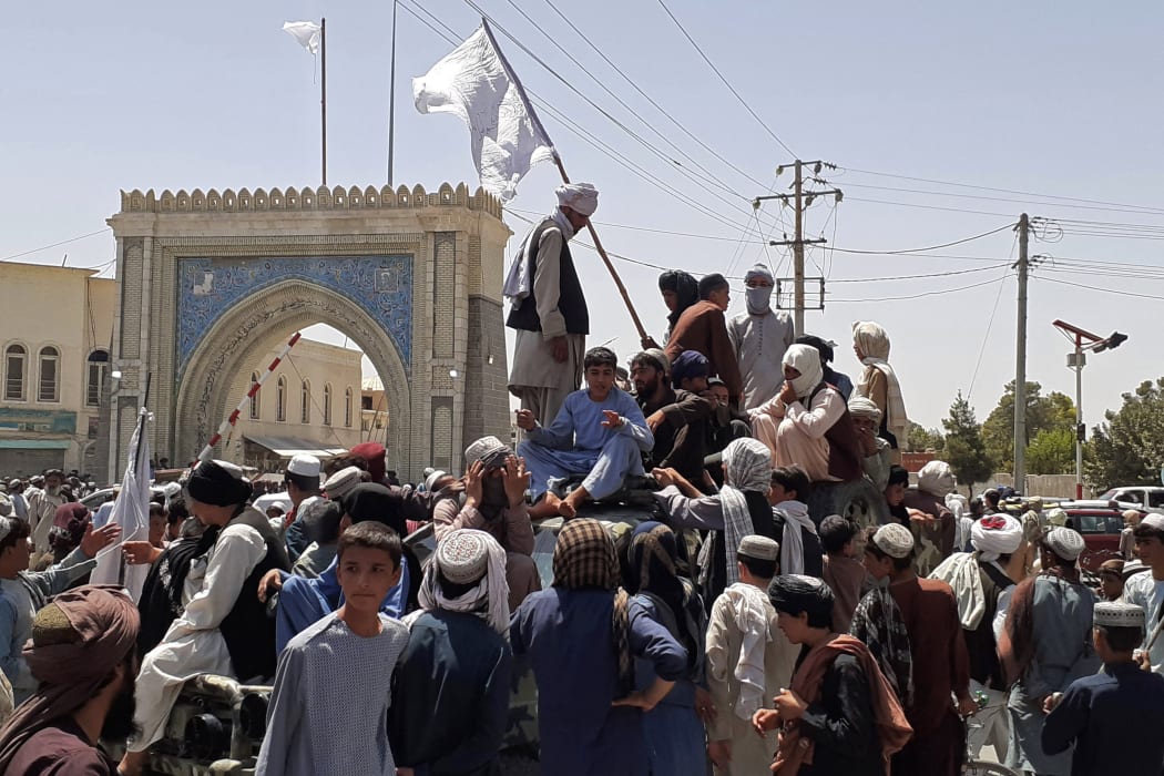 Taliban fighters stand on a vehicle along the roadside in Kandahar on Friday.