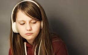Bored tween wearing headphones