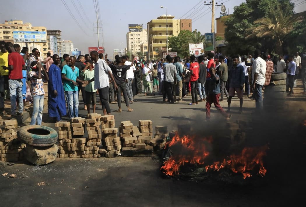 Sudanese protesters burn tyres to block a road in 60th Street in the capital Khartoum, to denounce overnight detentions by the army of members of Sudan's government, on October 25, 2021.