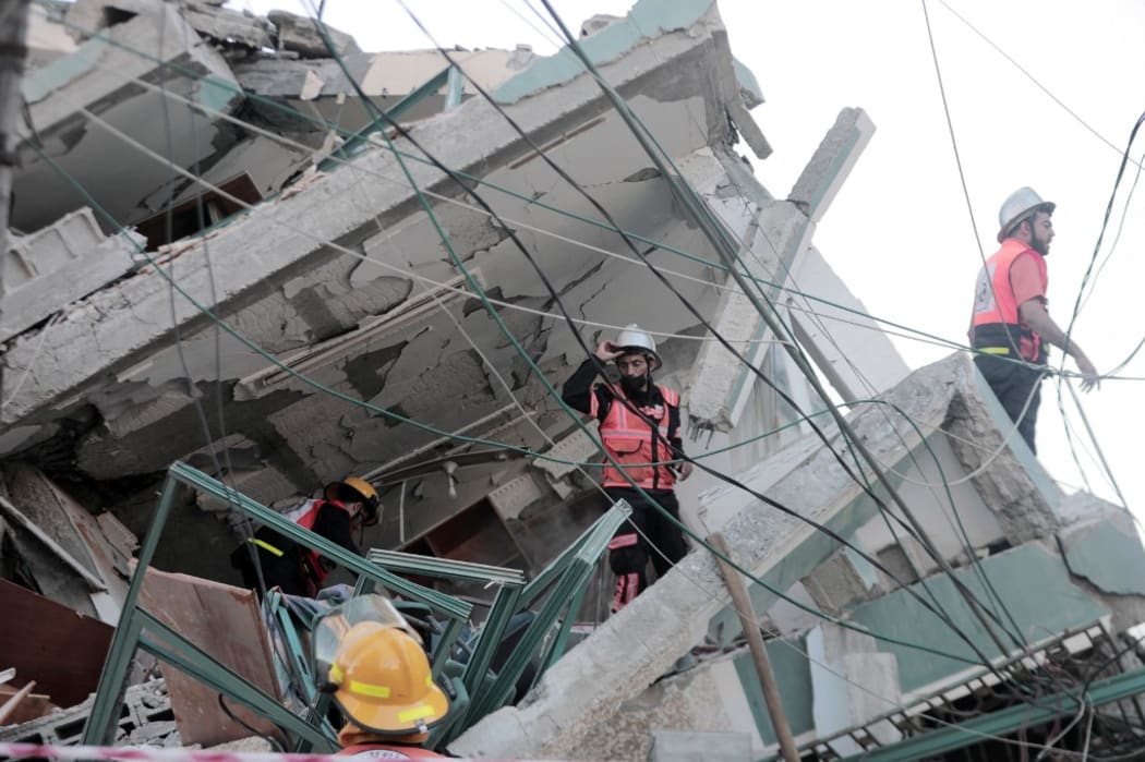 Palestinian journalists stand in shock following the destruction of Jala Tower, which was housing international press offices, by an Israeli airstrike in the Gaza Strip on May 15, 2021.
