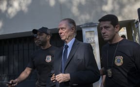 Brazil's Olympic Committee chief Carlos Nuzman (C) is escorted from his home by federal police in Rio de Janeiro on October 5, 2017.
