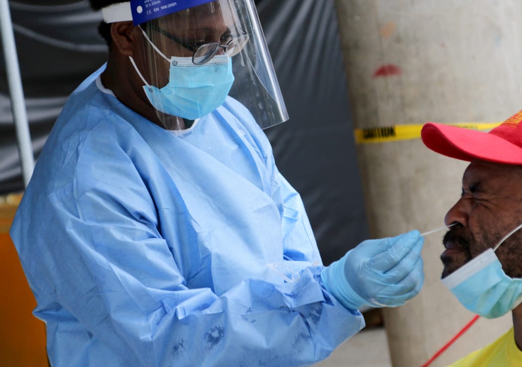 A health worker takes a swab from a man to test for Covid-19 at a makeshift clinic in Port Moresby on 1 April, 2021.