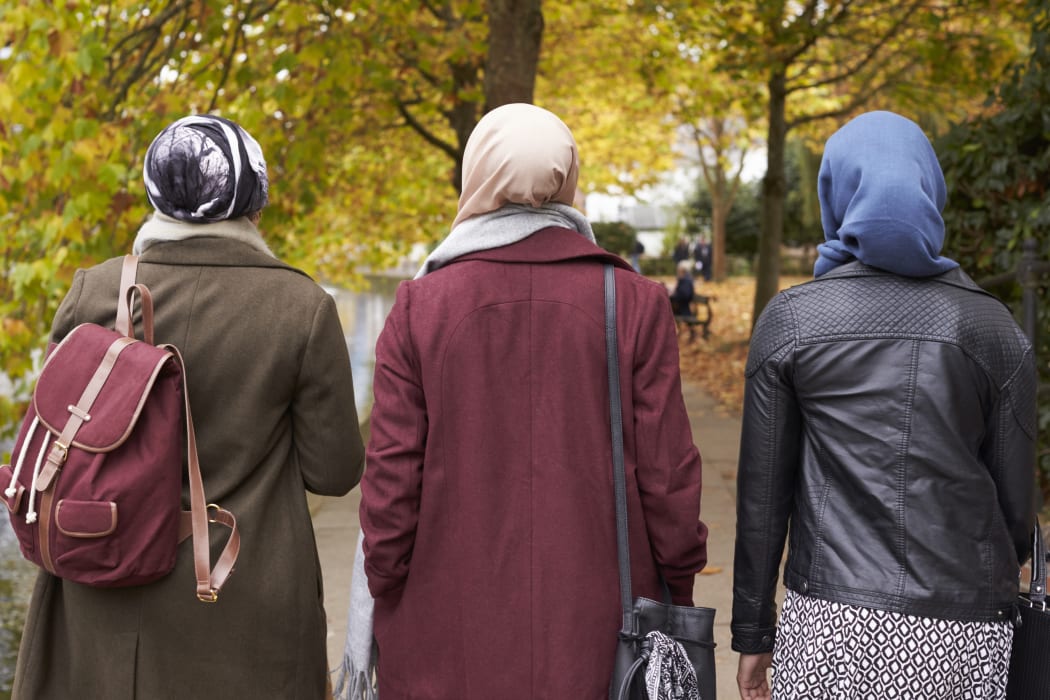 Muslim women walking in urban environment.