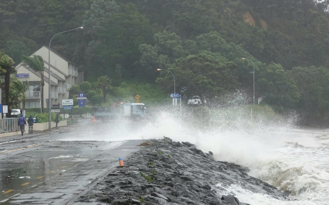 Big swells crash onto State Highway 11 in Paihia.