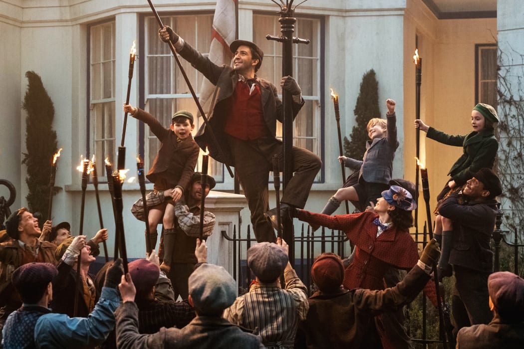 Jack (Lin-Manuel Miranda) Mary Poppins (Emily Blunt) and the Banks children with a crew of street lamplighters at 17 Cherry Tree Lane.