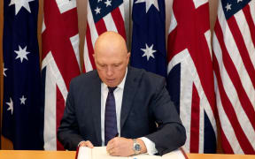 This handout photo taken and released on November 22, 2021 by the Australian Defence Force shows Australia's Minister for Defence Peter Dutton signing the Exchange of Naval Nuclear Propulsion Information Agreement along with British and United States during a ceremony at Parliament House in Canberra. (Photo by Kym Smith / Australian Defence Force / AFP) / ----EDITORS NOTE ----RESTRICTED TO EDITORIAL USE MANDATORY CREDIT " AFP PHOTO / AUSTRALIAN DEFENCE FORCE" NO MARKETING NO ADVERTISING CAMPAIGNS - DISTRIBUTED AS A SERVICE TO CLIENTS