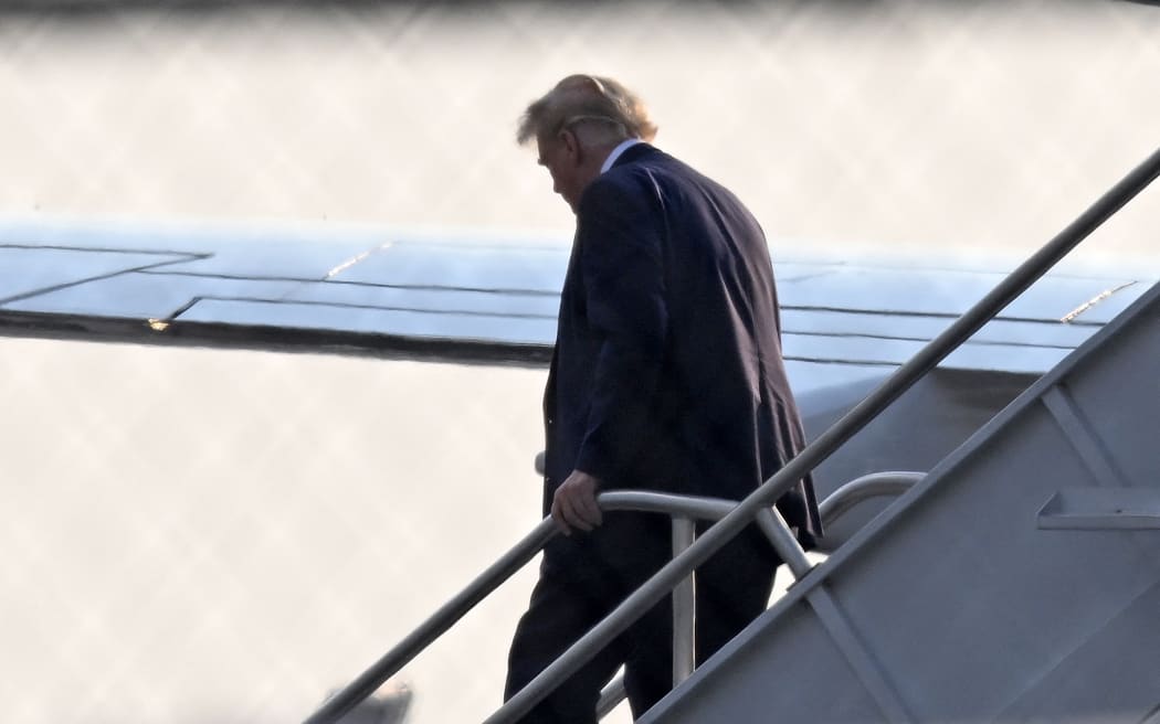 Former US President Donald Trump steps off his plane Trump Force One upon arrival at Atlanta Hartsfield-Jackson International Airport on his way to the Fulton County Jail in Atlanta, Georgia, on August 24, 2023. Former US President Donald Trump and 18 others have until August 25, 2023 to surrender at the courthouse after being indicted on 41 counts related to their efforts to overturn the 2020 US Presidential election.