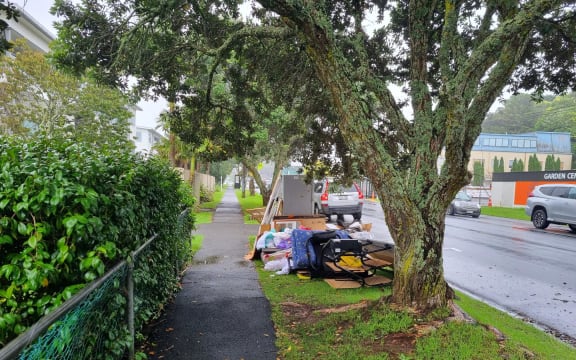 Debris piled up on the roadside in Browns Bay after the suburb flooded in January 2023.