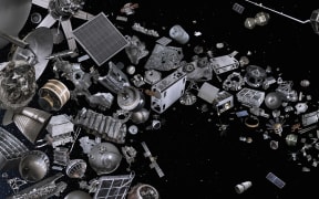 A photo of outer space showing human machines, drones and devices strewn across the blackness.