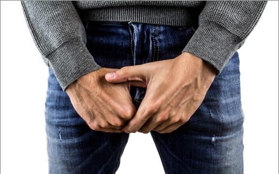 Image of a man with his hands protecting his balls.