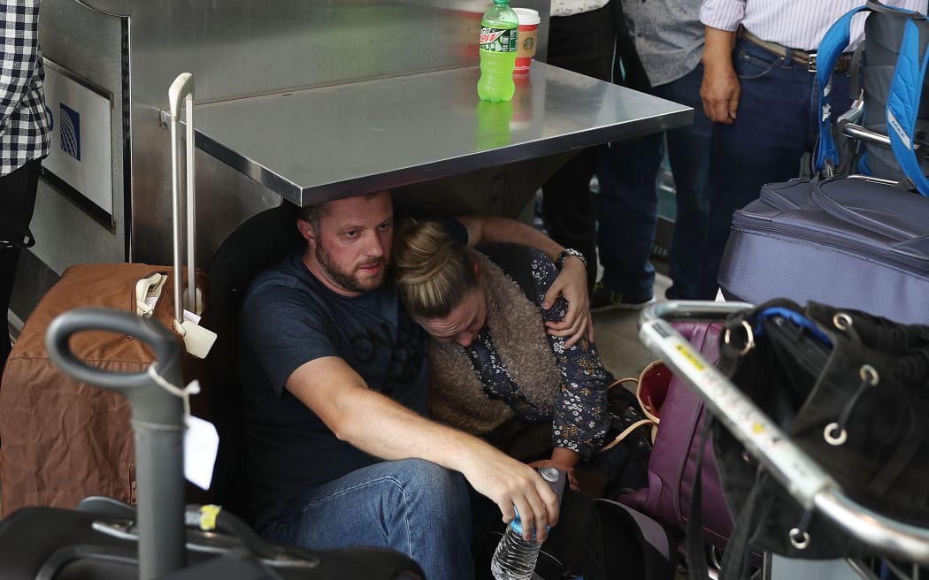 Travellers take cover at the Fort Lauderdale-Hollywood International airport.