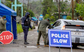 Fiji security forces inspect cars at a security check post at a residential area as they enforce face mask protocols in Fiji's capital Suva.