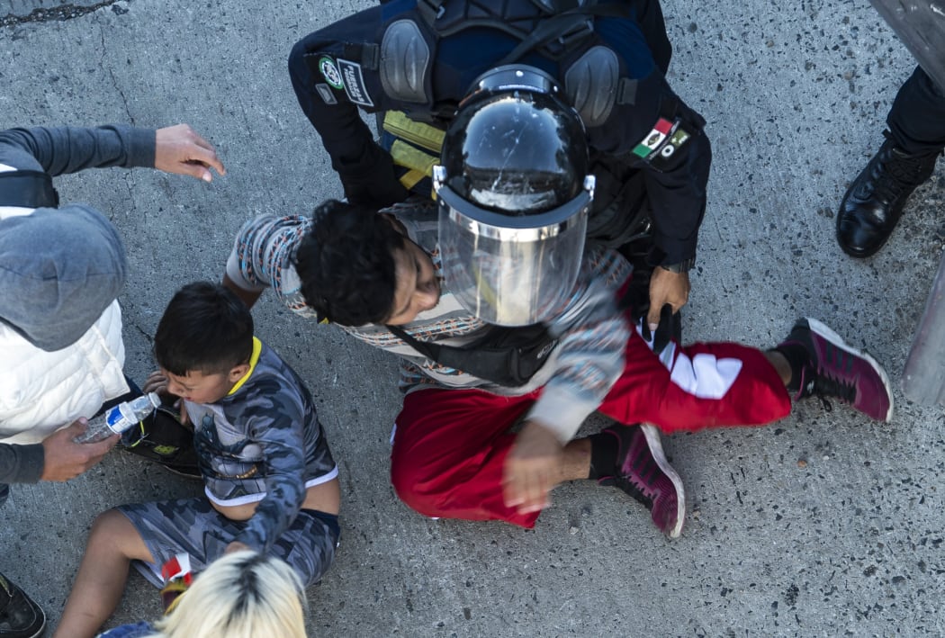Central American migrants are stopped by Mexican police forces as they reach the El Chaparral border crossing, in Tijuana, Baja California State, Mexico, on November 25, 2018.