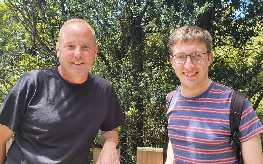 Ecologists with an interest in epiphytes: KC Burns and Tom Dawes stand in front of a climbing rata growing up a larger tree.