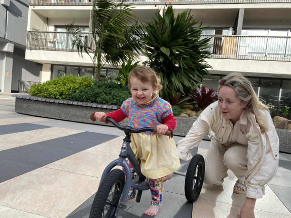 Emma Quigan with her daughter Mabel in the shared courtyard of their apartment complex.