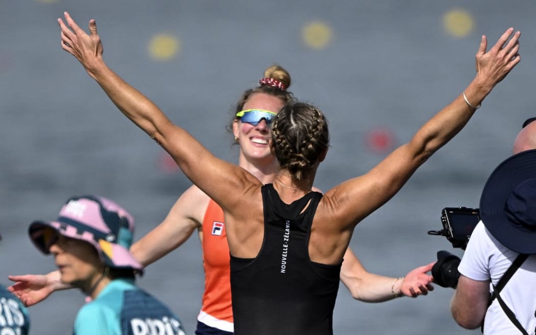 Netherlands' gold medallist Karolien Florijn (L) and New Zealand's silver medallist Emma Twigg celebrate after the women's single sculls final rowing competition at Vaires-sur-Marne Nautical Centre in Vaires-sur-Marne during the Paris 2024 Olympic Games on August 3, 2024. (Photo by Olivier MORIN / AFP)