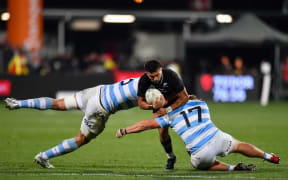 Richie Mo'unga of the All Blacks is tackled by Tomas Lavanini of Argentina and Mayco Vivas of Argentina, 2022.