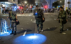 Police officers searching for evidence after clashes with protesters following a march against a controversial extradition bill in Hong Kong early.