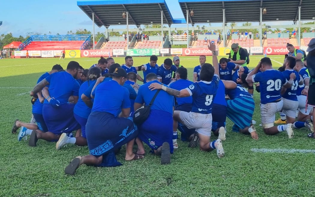 Manu Samoa's team pray after their win.