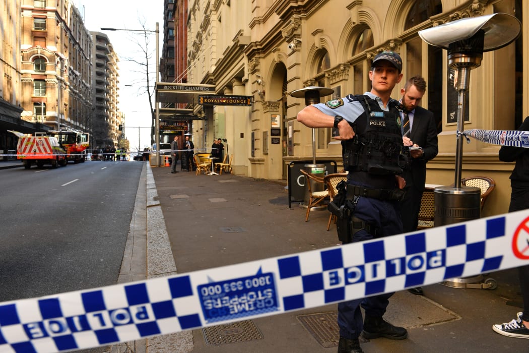 Police gather at the crime scene after a man stabbed a woman and attempted to stab others in central Sydney.