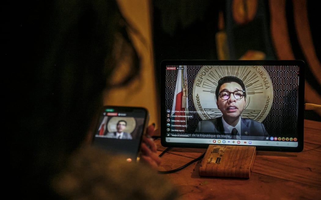 A resident of Antananarivo watches Madagascar President Andry Rajoelina’s address to the nation via the official Facebook page of the Presidency of Madagascar, from her home in Antananarivo on October 13, 2025. Madagascar's embattled President Andry Rajoelina said on October 13, 2025 he was sheltering in a "safe space" after an attempt on his life.
"I was forced to find a safe place to protect my life today. In all this, I never stop looking for solutions," the 51-year-old leader said in a live address on Facebook, without revealing his location. (Photo by RIJASOLO / AFP)